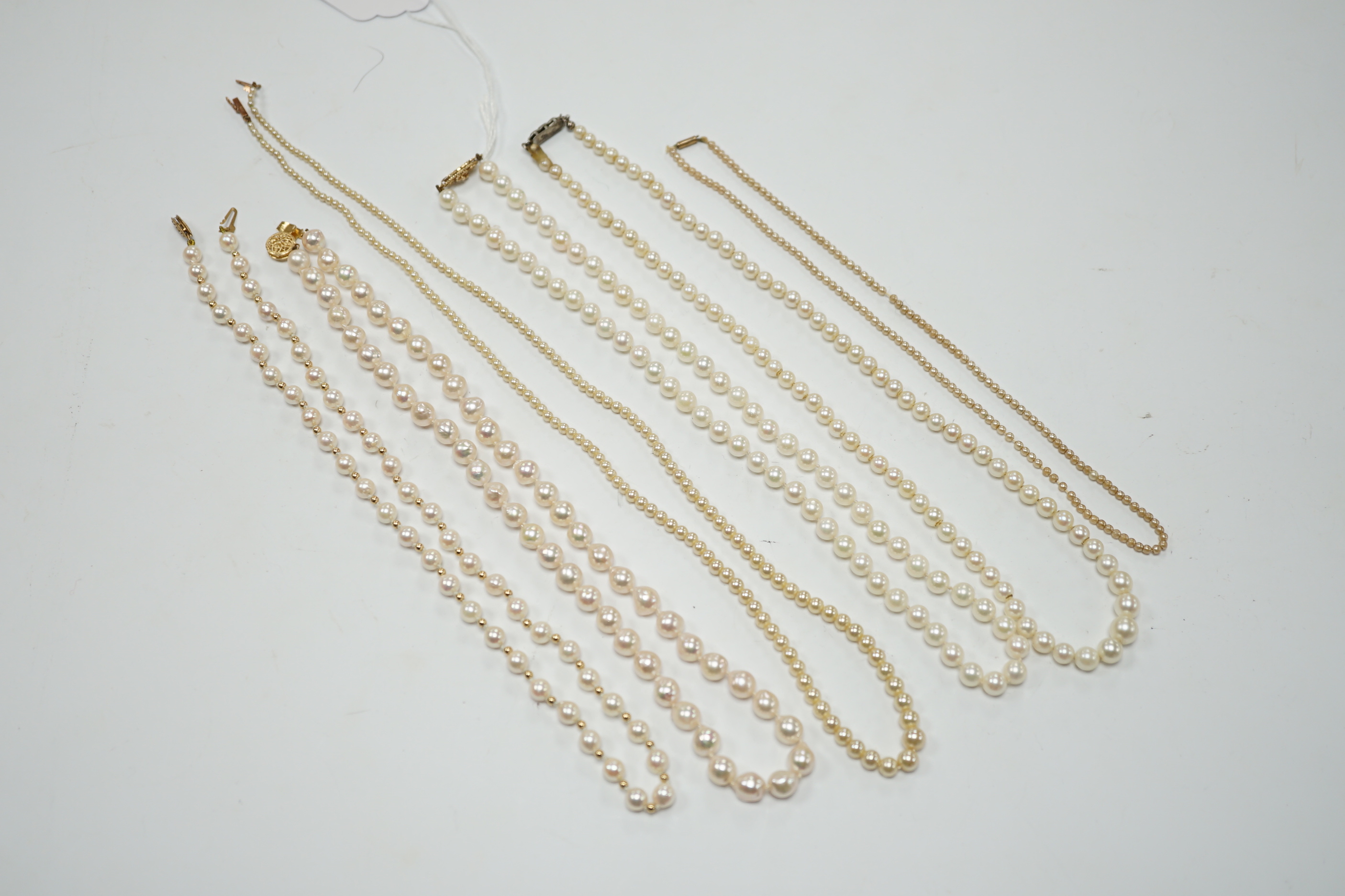 Five assorted single strand cultured pearl necklaces, including four with 9ct clasps, largest 47cm and one other simulated pearl necklace.